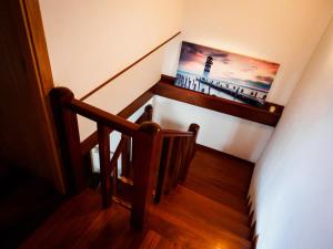 uma escada com uma imagem de um farol na parede em Casa de playa TABI Caión- A Coruña (VUT-CO-000899) em Cayón