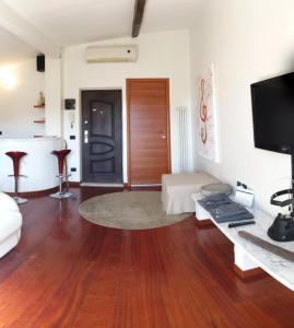 ein Wohnzimmer mit Massivholzboden und einem TV in der Unterkunft Splendida mansarda open space, finiture di lusso. in Carrara
