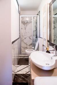 La salle de bains est pourvue d'un lavabo, de toilettes et d'une douche. dans l'établissement Splendida mansarda open space, finiture di lusso., à Carrara