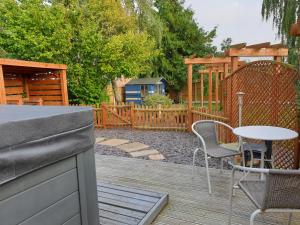 a patio with a table and chairs and a fence at Ruth's Rest Shropshire Country Retreat with private Hot Tub & Views countryside in Shrewsbury
