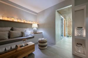 ein Schlafzimmer mit einem Bett, einem Tisch und einem Stuhl in der Unterkunft Santa Maria Luxury Suites & Spa in Adamas