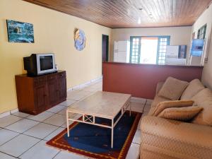 ein Wohnzimmer mit einem Sofa und einem TV in der Unterkunft RANCHO DA PISCINA EM BONITO in Bonito