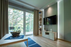 een woonkamer met een groot raam en een televisie bij Apartament MOUNTSEA Pobierowo , Grunwaldzka in Pobierowo