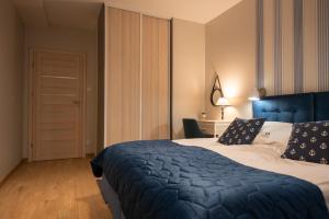 - une chambre avec un grand lit et une couette bleue dans l'établissement Apartament MOUNTSEA Pobierowo , Grunwaldzka, à Pobierowo