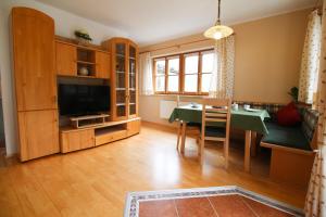 a living room with a dining table and a television at Appartement Berglerhof in Filzmoos