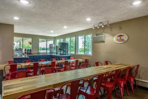une salle de conférence avec une grande table et des chaises rouges dans l'établissement Super 8 by Wyndham Duluth, à Duluth