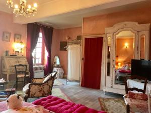 a living room with a couch and a red curtain at Maison Marthe B & B in Saint-Sauveur-en-Puisaye