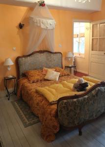 een slaapkamer met een groot bed met een baldakijn bij Maison Marthe B & B in Saint-Sauveur-en-Puisaye