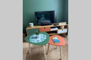 een woonkamer met een tafel en een televisie bij T2 rue du port de Cancale en baie du Mont Saint Michel in Cancale