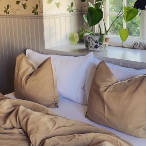 a bed with three pillows on top of it at Villamilsten B&B in Lidköping