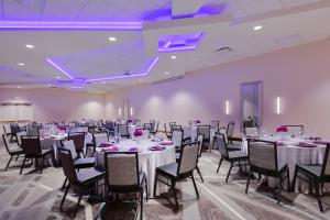 a banquet hall with tables and chairs and purple lighting at Holiday Inn La Mirada Buena Park by IHG in La Mirada +26 photos