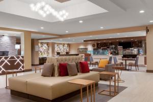 a lobby with a couch and some tables and chairs at Holiday Inn La Mirada Buena Park by IHG in La Mirada