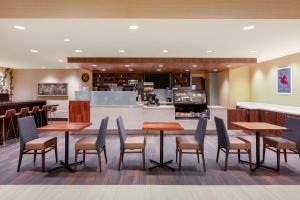 a restaurant with tables and chairs and a bar at Holiday Inn La Mirada Buena Park by IHG in La Mirada