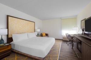 a bedroom with a large white bed and a desk at Holiday Inn La Mirada Buena Park by IHG in La Mirada