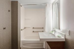 a bathroom with a sink and a tub and a toilet at Holiday Inn La Mirada Buena Park by IHG in La Mirada