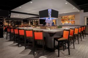 a bar in a restaurant with orange chairs at Holiday Inn La Mirada Buena Park by IHG in La Mirada