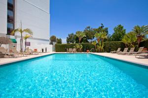a swimming pool with blue water in a building at Holiday Inn La Mirada Buena Park by IHG in La Mirada