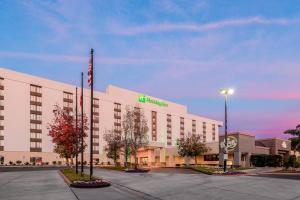 a hotel building with a green sign on it at Holiday Inn La Mirada Buena Park by IHG in La Mirada