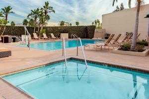a swimming pool at a resort with lounge chairs at Holiday Inn La Mirada Buena Park by IHG in La Mirada
