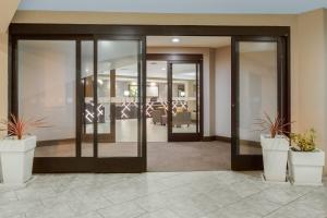 an office lobby with glass doors and potted plants at Holiday Inn La Mirada Buena Park by IHG in La Mirada