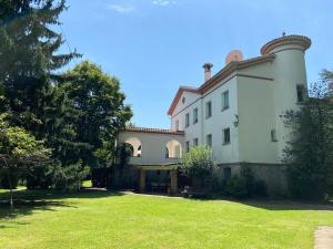 a large white building with a grass yard at Espectacular Casa Chateau en el centro de Olot in Olot