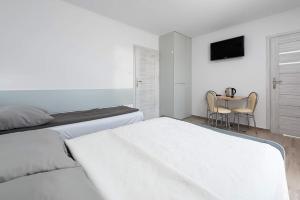 ブワディスワボボにあるVilla Altair4kidsの白いベッドルーム(ベッド2台、テーブル付)