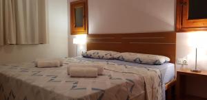 a bedroom with a large bed with two pillows on it at Casa MALIBU in Son Bou