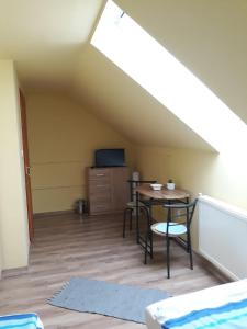 a room with a table and chairs in a attic at Kis Rigó vendégház in Salgótarján