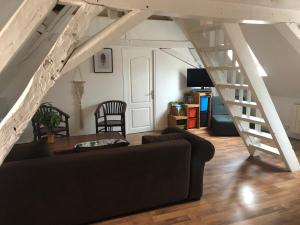 uma sala de estar com um sofá e uma escada em Le Grand Appartement - 90m2- 2 chb , 1 mezzanine - 6pers em Romorantin