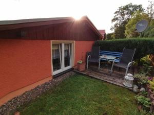 a backyard with a table and chairs on a deck at Sandsteinperle in Reinhardtsdorf