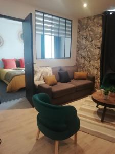 - un salon avec un canapé et un fauteuil vert dans l'établissement appartement topaze, à Concarneau