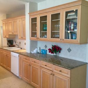 a kitchen with wooden cabinets and a vase of flowers at Island House Beach Resor 13N in Point O'Rocks