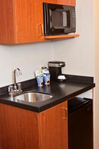 
a kitchen with a sink and a microwave at Holiday Inn Express Hotel & Suites Pittsburgh-South Side, an IHG Hotel in Pittsburgh
