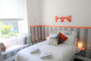 1 dormitorio con cama con almohadas y ventana en The Valentine - Townhouse Hotel, en Edimburgo