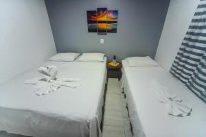dos camas sentadas una al lado de la otra en una habitación en Pousada São José, en Barreirinhas