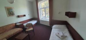 プラハにあるホテル イェラベックのベッド1台、ソファ、窓が備わる小さな客室です。