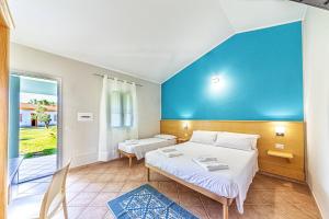 a bedroom with a bed and a blue wall at Agriturismo Is Cortillaris in Càbras