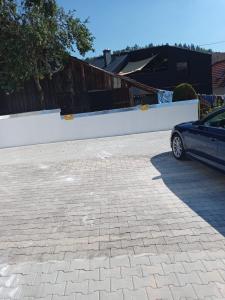 un'auto parcheggiata in un parcheggio vicino a un muro bianco di da GIUSEPPE a Tuttlingen