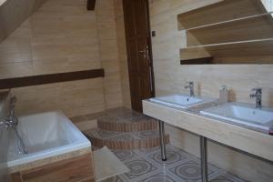 Janovice的住宿－Penzion Kota 509，浴室配有2个盥洗盆和1个浴缸。