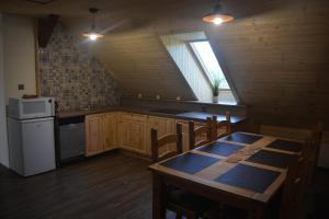uma cozinha com uma mesa e um frigorífico branco em Penzion Kota 509 em Janovice