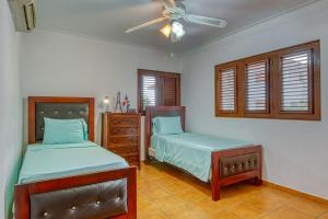 - une chambre avec 2 lits et un ventilateur de plafond dans l'établissement Marechiaro - Apartamento Vista Al Mar - Playa Juan Dolio, à Juan Dolio
