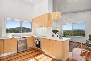 an open kitchen with wooden cabinets and windows at Seascape Scotts Head in Scotts Head