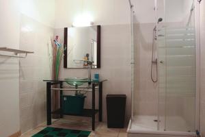 a bathroom with a sink and a shower with a glass door at Résidence cannelle in Les Trois-Îlets
