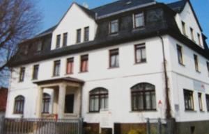 a large white house with a black roof at Pension Zur alten Fachschule in Triptis