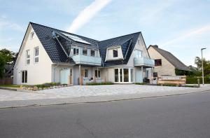 a large white house with a black roof at Dat-Meerhus in Büsum