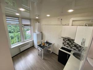 a small kitchen with a table and a refrigerator at Studio with separate bed room in Truskavets