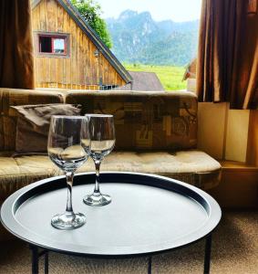 twee wijnglazen op een tafel voor een bank bij Mobilný domček in Terchová