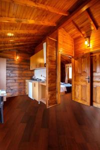 Habitación grande con paredes de madera y cocina. en Flora Handüzü Resort Bungalow, en Rize