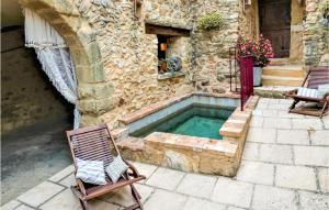 un edificio de piedra con un patio con piscina en 2 Bedroom Awesome Home In La Bastide Dengras, en La Bastide-dʼEngras