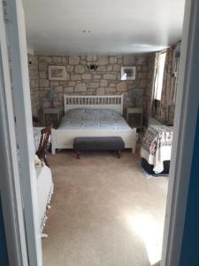 a bedroom with a bed and a stone wall at The Barn @ Hillside in Marnhull